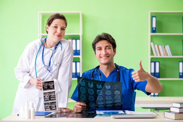 Woman and man gynecologists discussing medical case at the clini