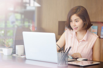 Asian working woman on workplace with laptop computer.