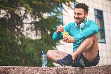 Man is eating fruit after morning workout