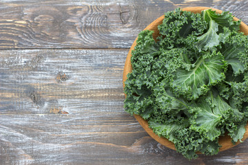Fresh green curly kale leaves on a wooden table. selective focus. free space. rustic style. healthy vegetarian food