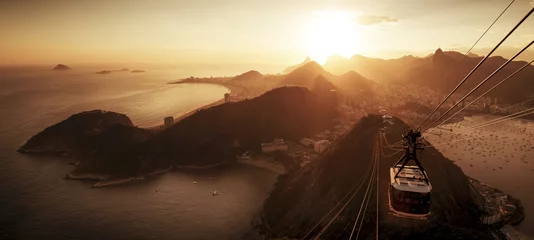 Fotobehang Copacabana, Rio de Janeiro, Brazilië Kabelbaan naar suikerbroodberg en panorama van Rio de Janeiro bij zonsondergang