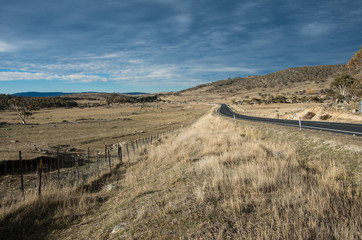 Road heading into the distance between two fields in rural australia