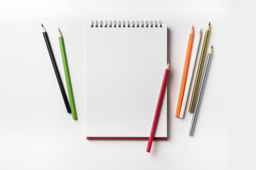 Top view of red spiral notebook and color pencil