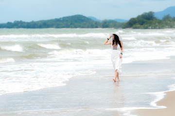 Fototapeta premium Summer Vacations. Lifestyle women relaxing and enjoying swing on the sand beach, fashion stunning women with white dress on the tropical island so happy and luxury in holiday summer. 