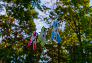 multi-colored three clothes pegs attached to a long rope in the courtyard
