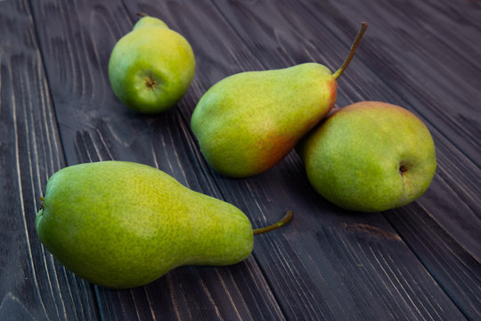 green ripe pear on black wooden background