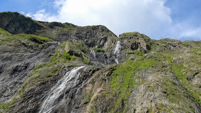 View waterfall scenes in mountains, national park Dombai, Caucasus, Russia. Summer landscape, sunshine weather, blue sky and sunny day