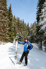 Young handsome man in winter sportswear looking away, wearing big mirrored ski mask