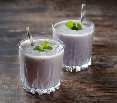 Blueberry smoothies juice a tasty healthy drink in a glass, drink the morning on wooden background.