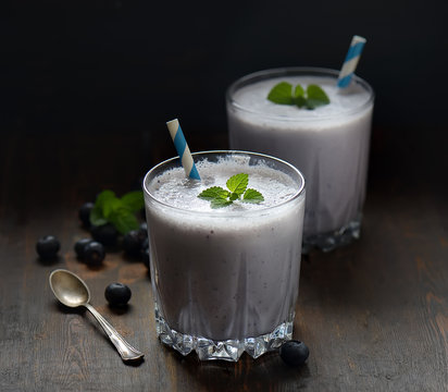 Blueberry smoothies juice a tasty healthy drink in a glass, drink the morning on wooden background.