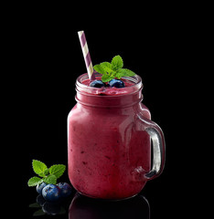 Blueberry  smoothie in glass jar on a black background