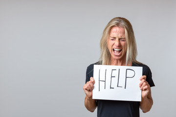 Mature woman holding paper with help lettering