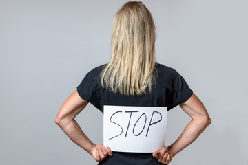 Slender tanned woman holding a Stop sign