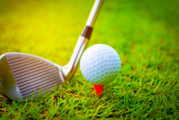 Golf ball and golf clubs on the Course. Golf ball on Orange tee. They are prepare to shot. Photo for health and game. 