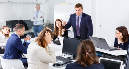 Businessman feeling angry to coworkers in office, pointing out mistakes in work