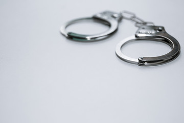 Handcuffs on a white background in the upper left corner of the frame.