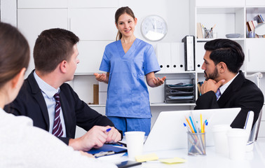 Doctor giving lecture for businessmen in office