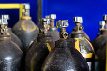 Black cylinders with oxygen are at the factory in the shop, close-up