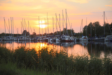 beautiful sunset over yacht harbour on river near greifswald germany
