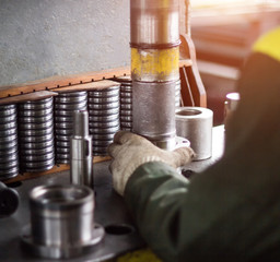 The worker assembles the pressing of the bearing into a metal clip on the machine, assembles the...