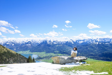 年轻女性坐在雪山悬崖边缘, 夏夫山 (电影《音乐之声》拍摄地),奥地利, 