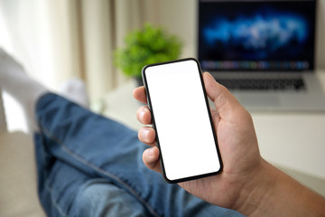 man on sofa holding phone with isolated screen in room house