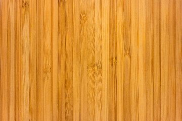 Texture of a board with a vertical pattern of bamboo fibers, soft focus