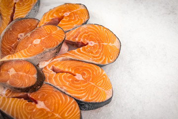 Sliced red fish on ice in the market. Close-up of pieces of fish with copy space