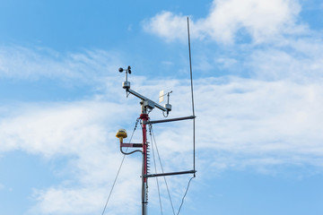 Automatic weather station, with a weather monitoring system. Against the background of a blue sky...