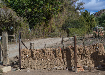 Portion of an old kraal wall constructed from mud and stone image in landscape format with copy...