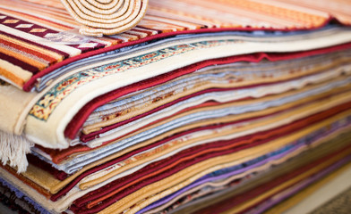 Stack of multicolored quality rugs  at carpet shop
