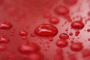 Closeup rain drops on red car with hydrophobic coating