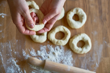 Women kneads and forms dough to look like bagel