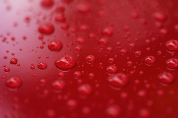 Closeup rain drops on red car with hydrophobic coating