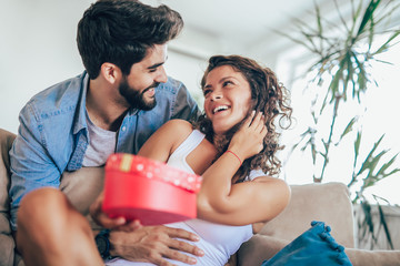 Man giving a surprise gift to woman at home