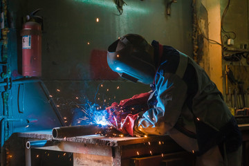 Metal welding worker in working process and fire