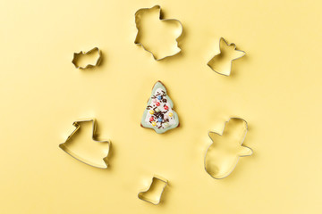 Christmas cookies various shape cutter on yellow background with copy space. Top view. Flat lay. Trendy colorful photo. Minimal style with colorful paper backdrop. Christmas concept
