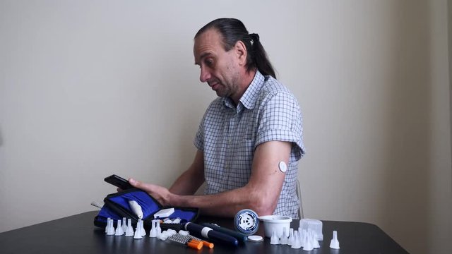 A man hands brings to the hand the smartphone for measuring glucose in the blood