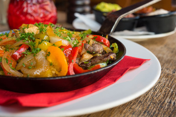 Mexikanisches Essen Fajita mit Rinder Fleisch und Gemüse in einer Eisen Pfanne gebraten mit Weizen Tortillias