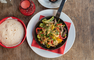 Mexikanisches Essen Fajita mit Rinder Fleisch und Gemüse in einer Eisen Pfanne gebraten mit Weizen Tortillias
