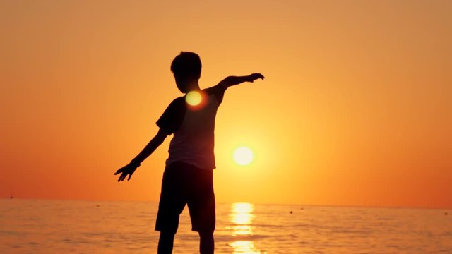 Silhouette of a boy standing on the beach, the concept of happiness, dream, human space, children's dream