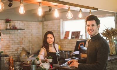 business owner using laptop working with laptop at the bar of the modern cafe