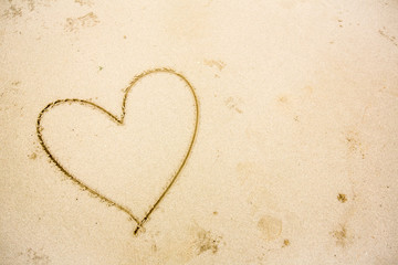 a heart in the sand on the beach.heart drawn on sand. 