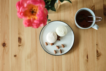  Sweets, flower and tea. Snack on a wooden table. Girls' favorite food and flowers.