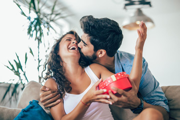 Man giving a surprise gift to woman at home