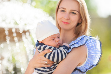 Mother holding a newborn baby in her arms, family portrait.
