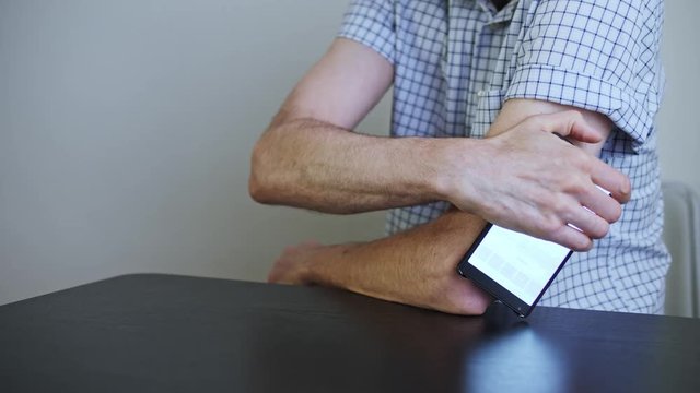 A man hands brings to the hand the smartphone for measuring glucose in the blood