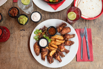 Mexikanisch Amerikanisches Essen marinierte Buffalo Chicken Wings mit Country Farmer Potatoes Kartoffeln und Sour Cream Dip