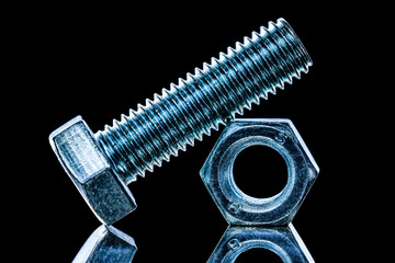Threaded construction nut bolt on black background