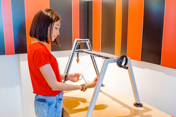Women students making experimental work in the field of mechanics and physics in modern laboratory 